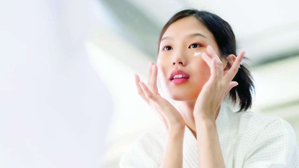 Attractive freshness asian woman clean face fresh water with care look to mirror in bathroom home background