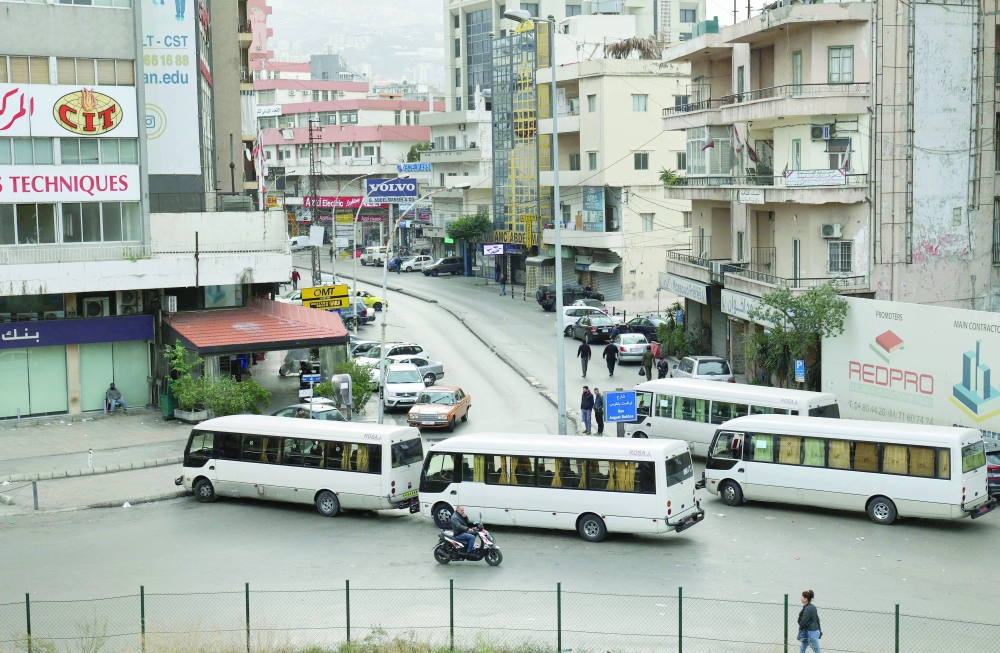 Buses block a road in Beirut during a general strike. -- AFP
