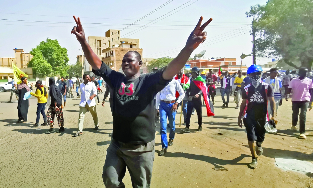 A Sudanese demonstrator flashes the victory sign during a protest in Khartoum. -- AFP

