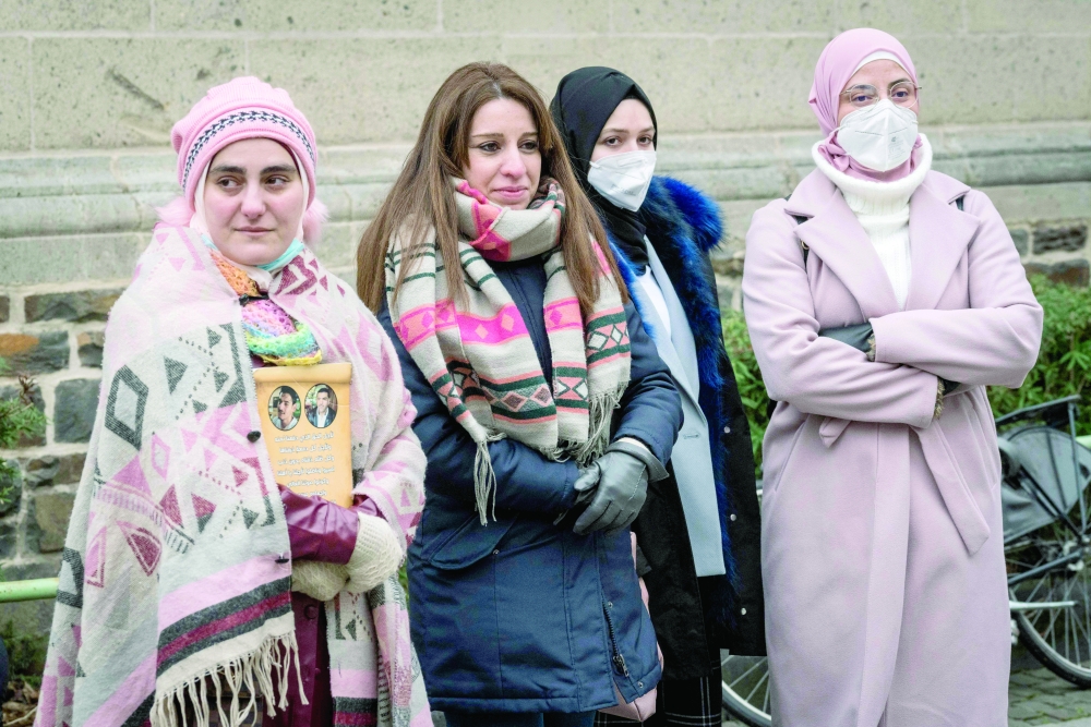 Women demonstrate outside the courthouse where former Syrian intelligence officer Anwar Raslan stood on trial in Koblenz, western Germany. -- AFP
