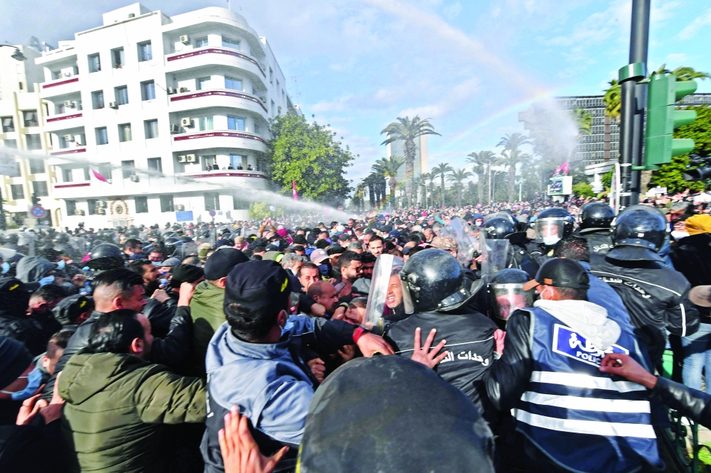 Tunisian demonstrators clash with police during protests against President Kais Saied, on the 11th anniversary of the Tunisian revolution in the capital Tunis on Friday. - AFP 