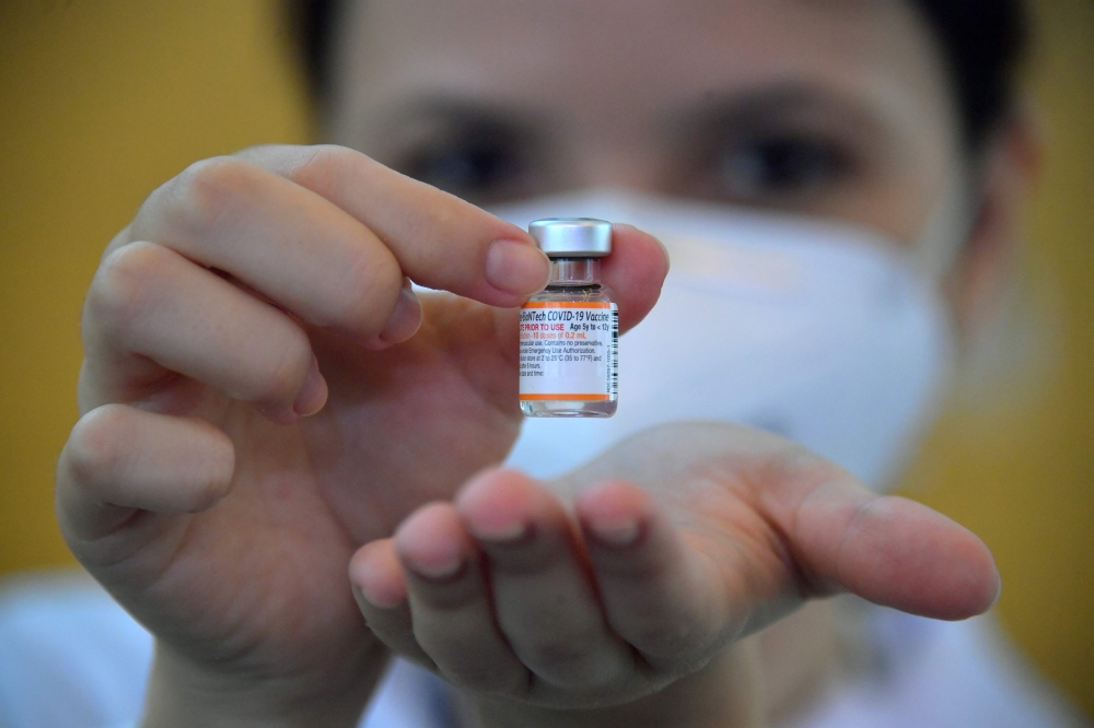 A health worker shows a dose of the Pfizer-BioNTech vaccine against COVID-19, at the Clinicas hospital in Sao Paulo, Brazil, on January 14, 2022. 