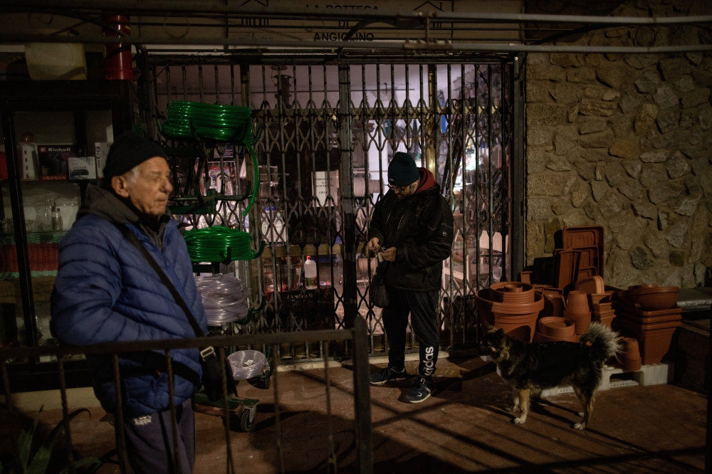 Francesco Dietrich, right, and his father in front of the shop owned by his partner’s family in Giglio, Italy on Wednesday, Jan. 12, 2022. 