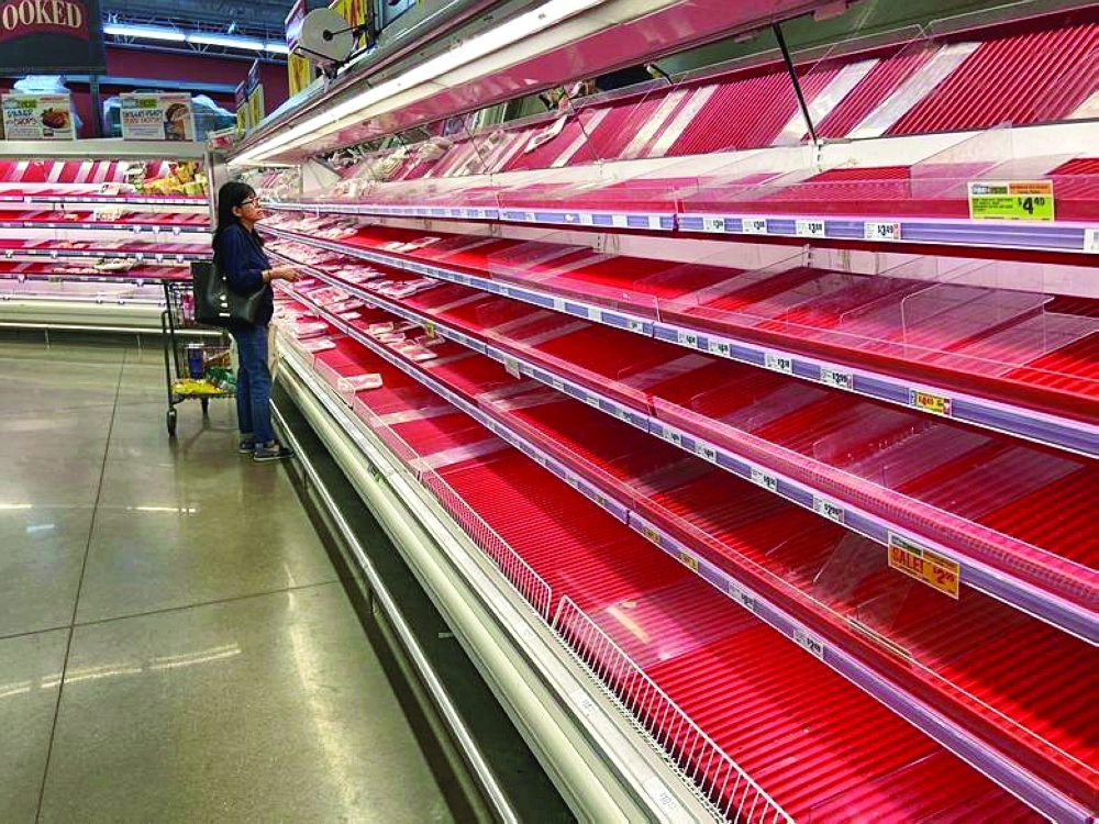 A shopper picks over the few items remaining in the meat section at a grocery store in Austin, Texas. — Reuters