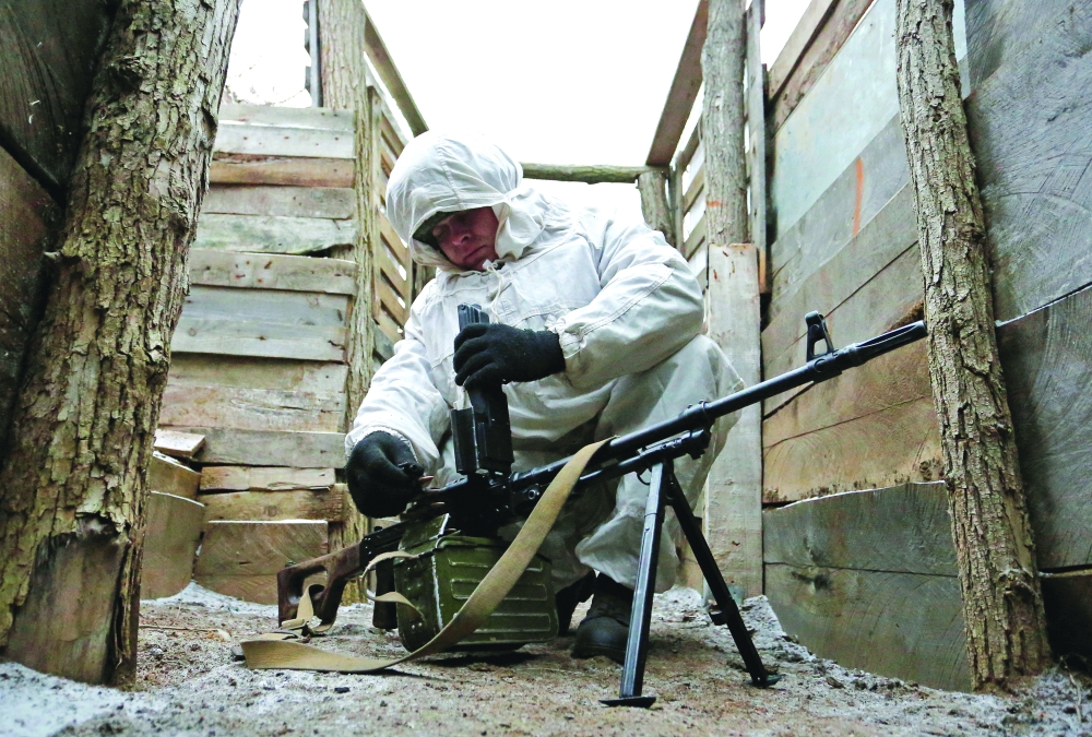 A militant of the self-proclaimed Donetsk People's Republic checks a machine gun at fighting positions on the line of separation from the Ukrainian armed forces near the rebel-controlled settlement of Yasne in Donetsk region, Ukraine. - Reuters
