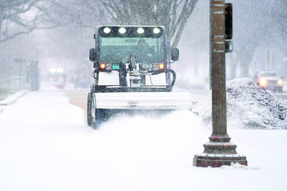 A snow sweeper clears sidewalks near the National Mall in Washington, DC, during a winter storm. — AFP