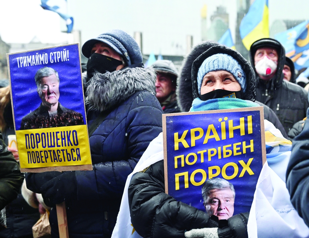 Supporters of Ukraine’s former leader Petro Poroshenko hold banner reading ‘Ukraine needs Poroshenko’ as they attend a rally during a court hearing in Kyiv. — AFP