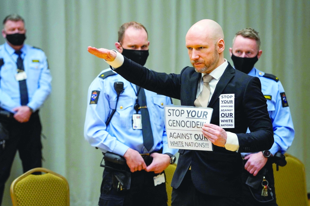 Anders Behring Breivik arrives on the first day of the trial where he is requesting release on parole at a makeshift courtroom in Skien prison, Norway. - AFP