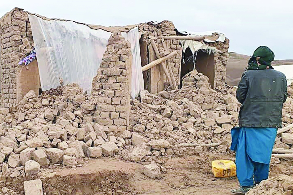 A resident stands near a damaged house at Qadis district in the southern part of Badghis province, after an earthquake hit the region.  - AFP

