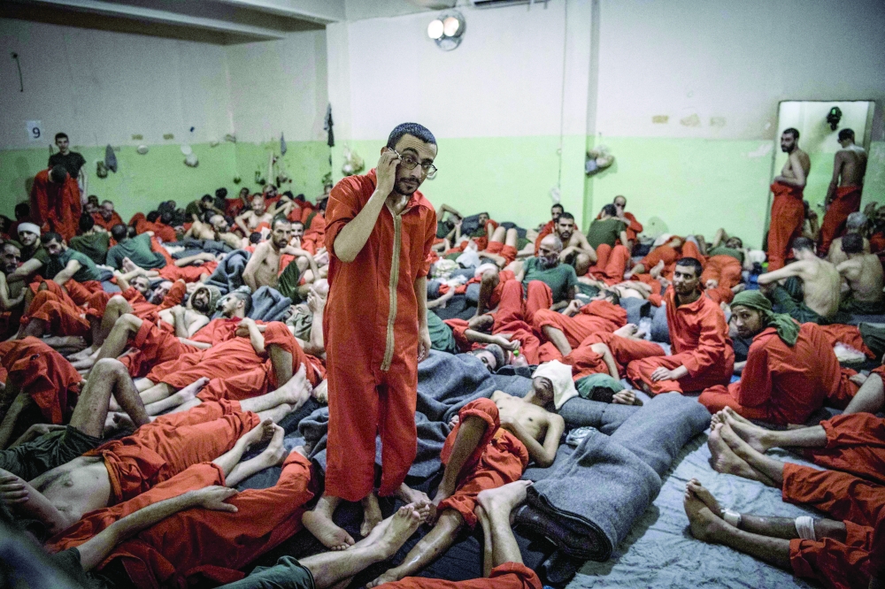 This file photo taken on October 26, 2019, shows men suspected of being affiliated with the IS group, gathered in a cell of the Sinaa prison in the Ghwayran neighbourhood of the northeastern Syrian city of Hasakeh. - AFP