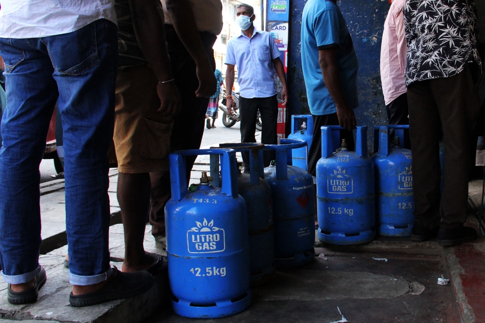 People queue to buy Liquefied Petroleum Gas (LPG) cylinders in Colombo on January 19, 2022, as shortages of essentials gripped the island following a severe shortage of foreign exchange to finance imports. (Photo by AFP)