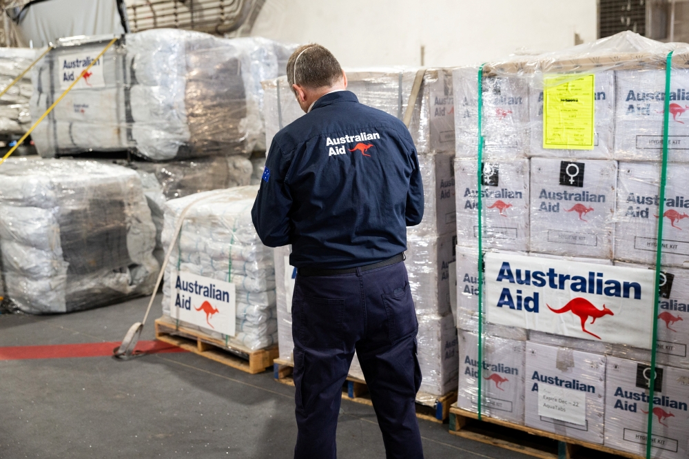 Department of Foreign Affairs and Trade Crisis Response Team Liaison Officer, Timothy Church, checks the pallets of humanitarian aid supplies embarked onboard HMAS Adelaide as the ship sails to support the nation of Tonga, January 20, 2022. 