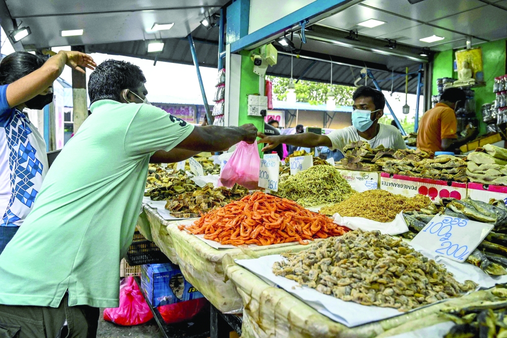 A vendor sells dried fish at a market in Colombo. — AFP