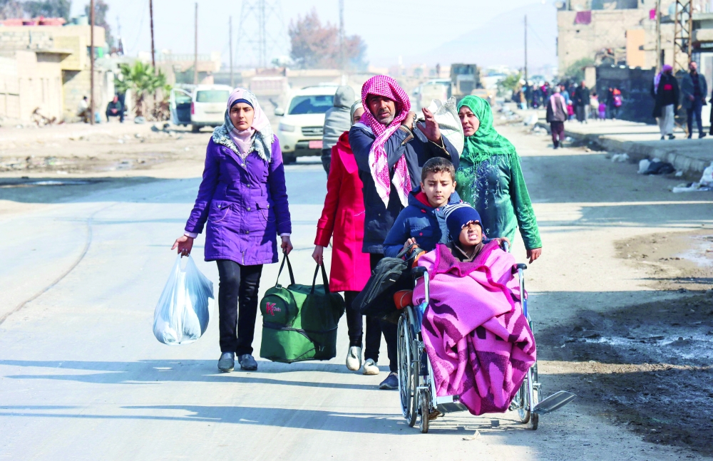 Syrians flee their homes in the Ghwayran neighbourhood in the northern city of Hasakeh on the third day of fighting between the IS group and Kurdish forces in Syria. - AFP