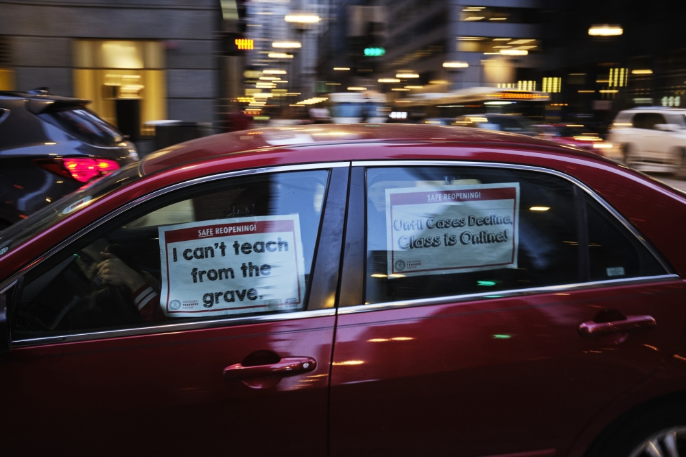 Signs adorn a car during a protest held by the Chicago Teachers Union during a dispute over coronavirus safety measures in Chicago, Jan. 5, 2022. (Mustafa Hussain/The New York Times)