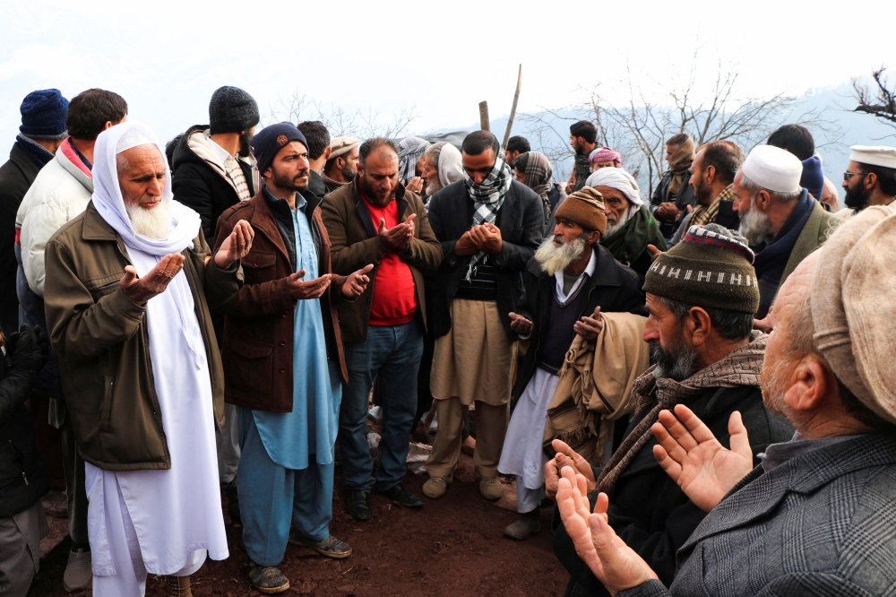 People pray as they attend the funeral of a boy, who was killed in a blast in Lahore, in Talgaran village on the outskirts of Muzaffarabad, Pakistan January 21, 2022. REUTERS/Stringer NO RESALES. NO ARCHIVE.
