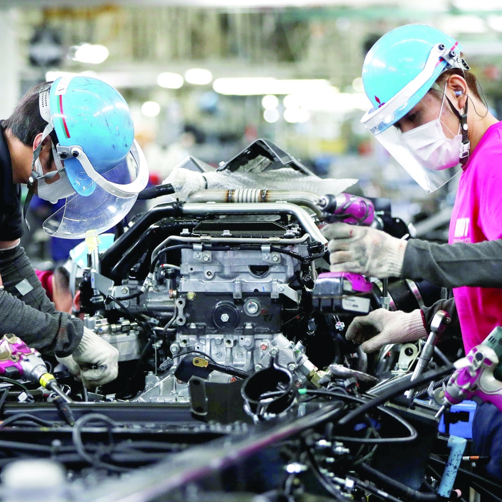 Employees work on the automobile assembly line at Kawasaki factory in Kawasaki, south of Tokyo.  — Reuters