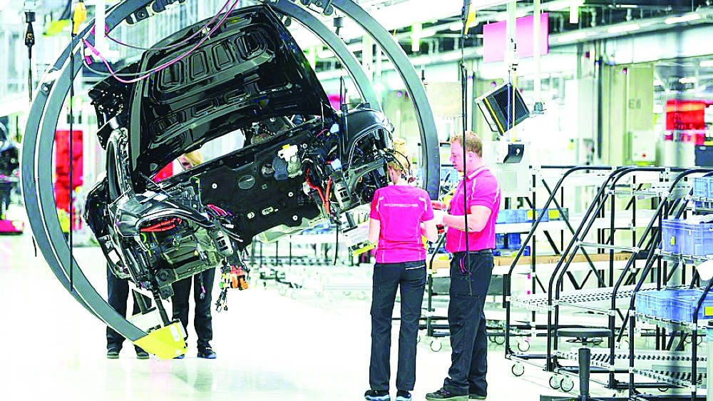Employees assemble a car at Porsche AG plant in Stuttgart, Germany. — AFP