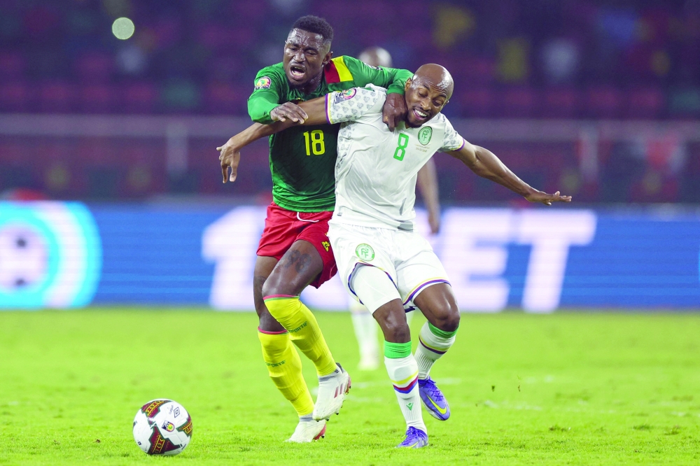 TOPSHOT - Cameroon's midfielder Martin Hongla (L) fights for the ball with Comoros' midfielder Fouad Bachirou (R) during the Africa Cup of Nations (CAN) 2021 round of 16 football match between Cameroon and Comoros at Stade d'Olembe in Yaounde on January 24, 2022.  (Photo by Kenzo Tribouillard / AFP)

