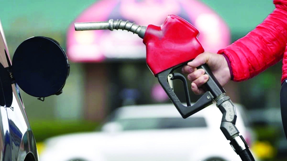 A worker holds a nozzle to pump petrol into a vehicle at a fuel station in San Francisco, California. — Reuters