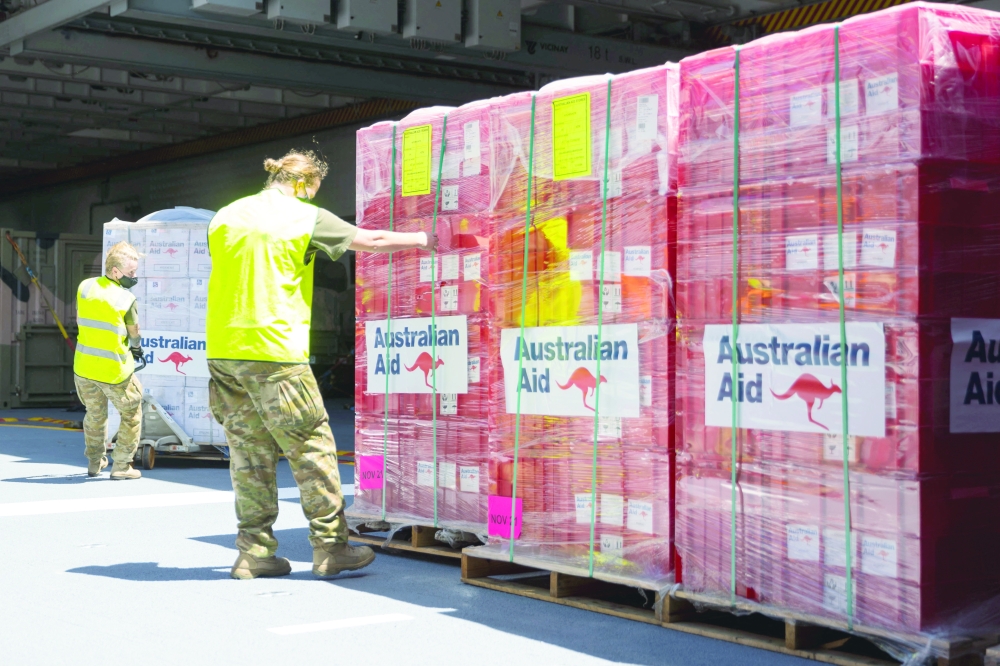 People prepare humanitarian aid as the HMAS Adelaide sails into the port of Nuku'alofa,Tonga, after a volcanic eruption and tsunami devastated the South Pacific archipelago. - Reuters