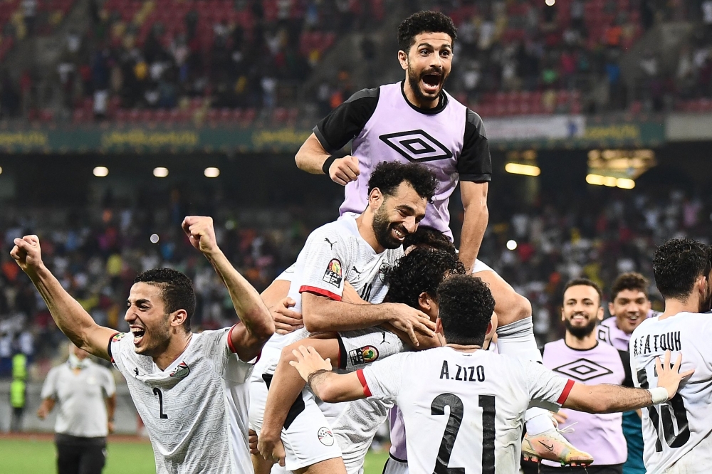 TOPSHOT - Egypt's forward Mohamed Salah (C) celebrates with teammates after winning the Africa Cup of Nations (CAN) 2021 round of 16 football match between Ivory Coast and Egypt at Stade de Japoma in Douala on January 26, 2022.  (Photo by CHARLY TRIBALLEAU / AFP)


