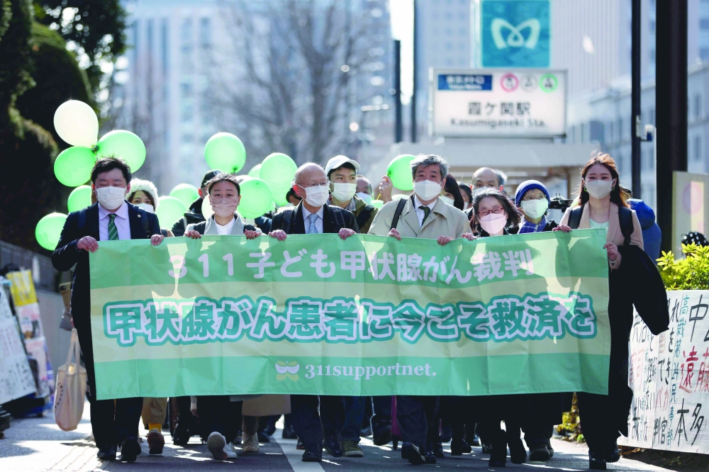 Supporters and lawyers of the six young people who were living in the Fukushima region when the March 11, 2011 tsunami caused the nuclear disaster, arrive in front of the Tokyo district court in Tokyo on Thursday, to file a class-action lawsuit against plant operator Tokyo Electric Power Company. - AFP