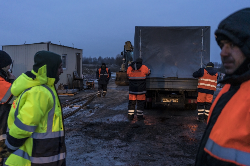 Road workers along the E-95 highway between Chernihiv and Kyiv in Sokyryn, Ukraine, Jan. 20, 2022. (Brendan Hoffman/The New York Times)