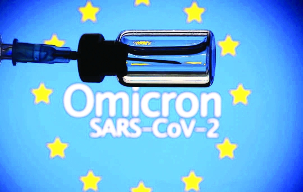 A vial and a syringe are seen in front of a displayed EU flag and words "Omicron SARS-CoV-2" in photo illustration.  — Reuters