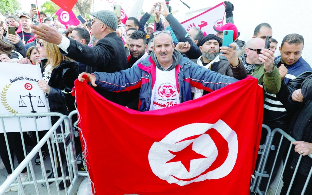 Supporters of Tunisian President Kais Saied carry national flags and banners during a protest against the Supreme Judicial Council in Tunis. - Reuters 