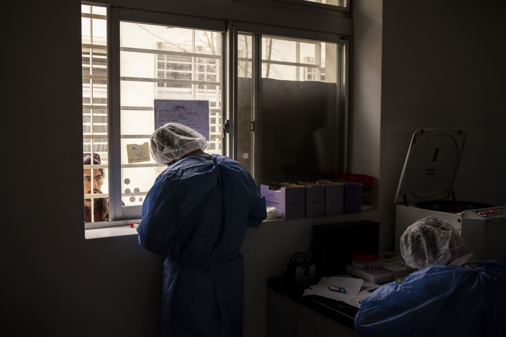 A lab worker performs a nose swab at the Afghan-Japan Communicable Disease Hospital in Kabul, Afghanistan, Jan. 17, 2022. (Jim Huylebroek/The New York Times)