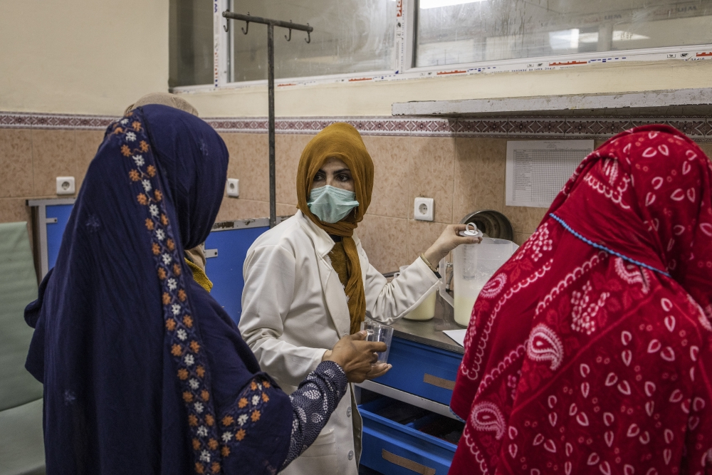 A nurse distributes formula at the malnutrition ward of the Indira Gandhi Children's Hospital in Kabul, Afghanistan, Jan. 12, 2022.  (Jim Huylebroek/The New York Times)