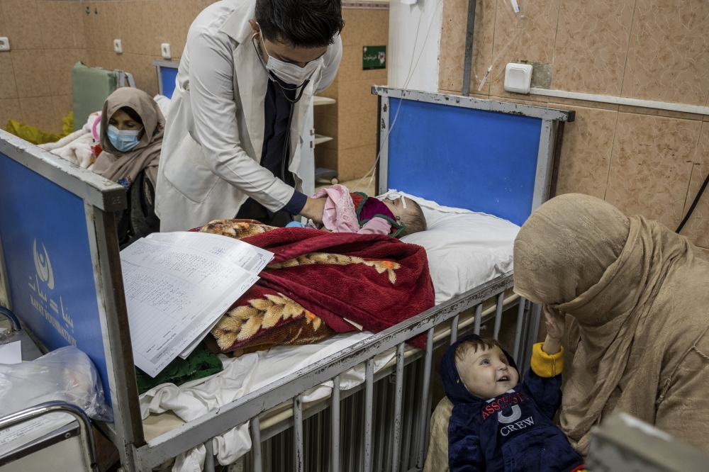 A doctor examines 7-month-old Amena at the malnutrition ward of the Indira Gandhi Children's Hospital in Kabul, Afghanistan, Jan. 12, 2022.  (Jim Huylebroek/The New York Times)