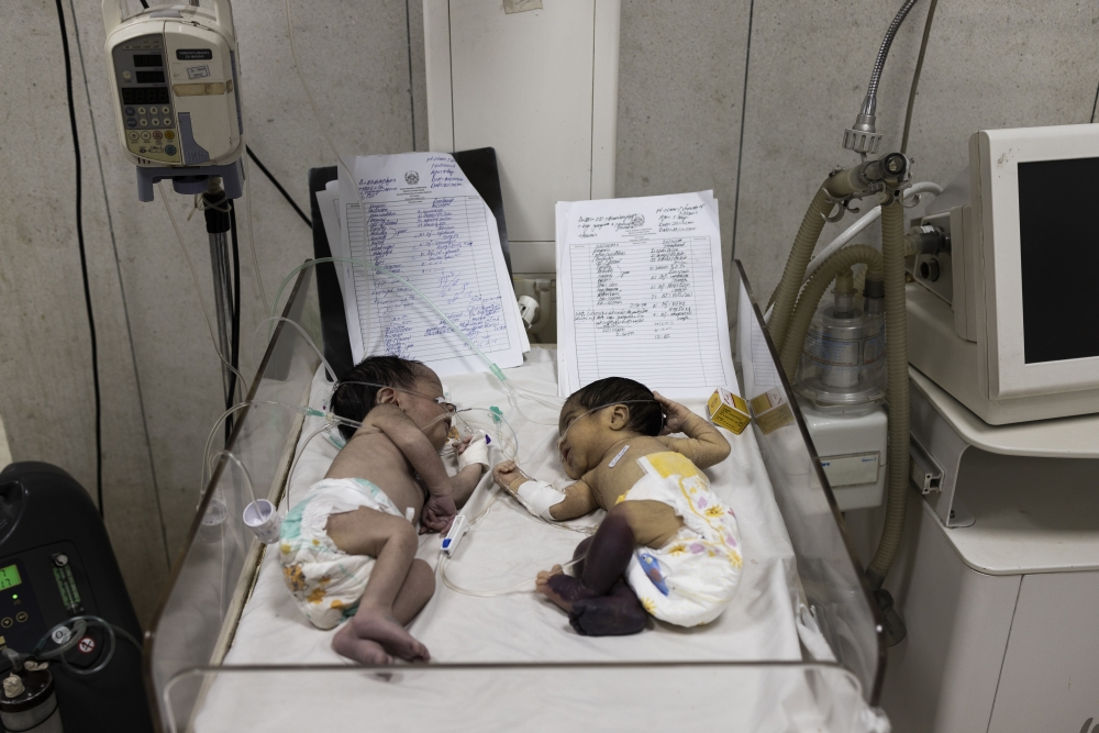 Infants double-occupy a bed at an intensive care ward for babies at the Indira Gandhi Children's Hospital in Kabul, Afghanistan, Jan. 12, 2022.  (Jim Huylebroek/The New York Times)