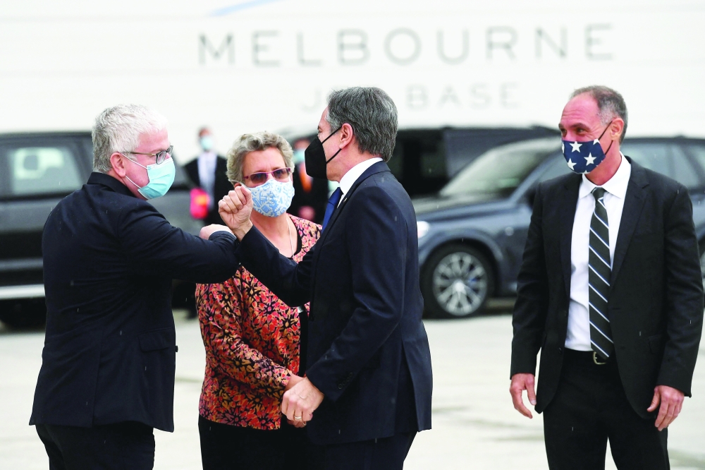 US Secretary of State Antony Blinken is greeted by Australia's Department of Foreign Affairs and Trade First Assistant Secretary Craig Chittick (L) after disembarking from his plane in Melbourne. - AFP