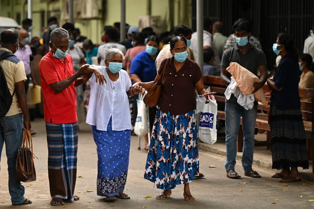 Patients leave a hospital as health workers hold a work strike in Colombo on February 11, 2022.