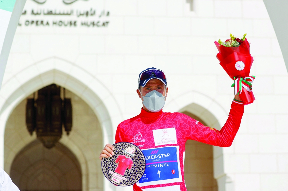 Quick-Step Alpha Vinyl Team's rider Fausto Masnada poses on the podium after winning the fourth stage of the Oman Tour between al-Sifah and Royal Opera House Muscat, in Muscat on February 13, 2022.  (Photo by Thomas SAMSON / AFP)


