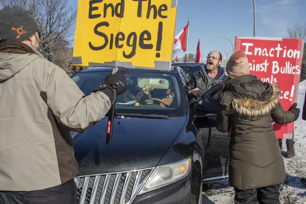 Counterprotesters block a small anti-government convoy in Ottawa, Ontario, Feb. 13, 2022. (Brett Gundlock/The New York Times)