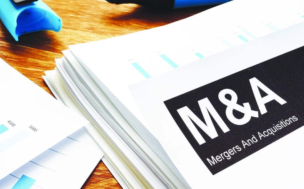 Documents about mergers and acquisitions m&a with a pen.