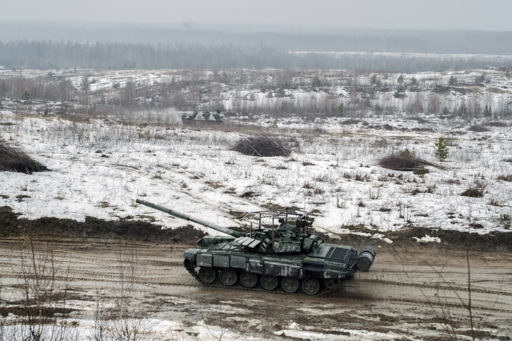 A tank moves through a muddy field during joint military exercises with Russia in Osipovichi, Belarus, on Thursday, Feb. 17, 2022. (Emile Ducke/The New York Times)