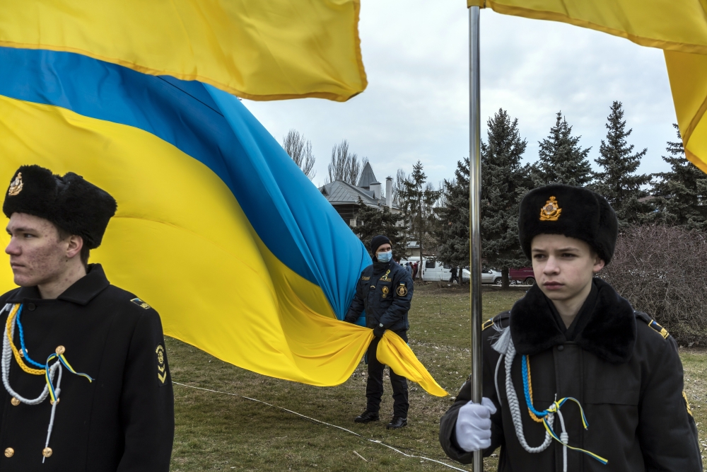 Naval cadets from a local maritime academy hold Ukrainian flags during a ceremony to mark Unity Day in Kherson, Ukraine, on Wednesday, Feb. 16, 2022.  (Brendan Hoffman/The New York Times)