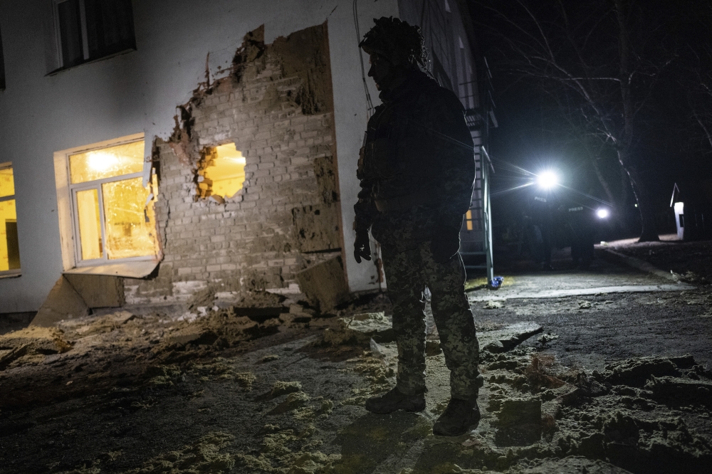 Ukrainian soldiers outside a kindergarten damaged by shelling in the town of Stanytsia Luhanska, Ukraine, Feb. 17, 2022.  (Lynsey Addario/The New York Times) 