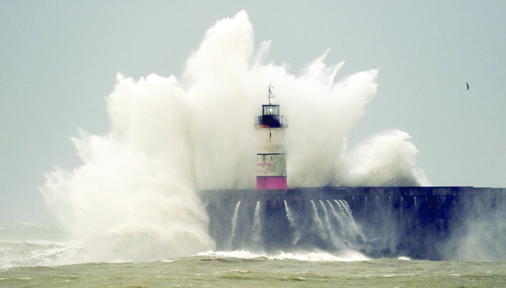 Waves crash over Newhaven Lighthouse and the harbour wall in Newhaven, southern England on Friday, as Storm Eunice brings high winds across the country. - AFP  