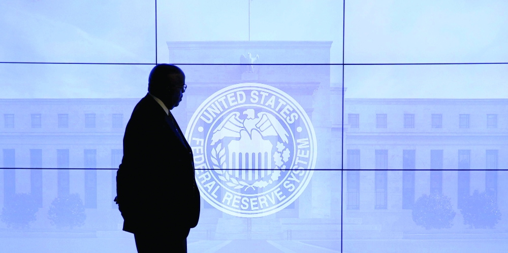 A security guard walks in front of an image of the Federal Reserve in Washington, in this file photo. — Reuters