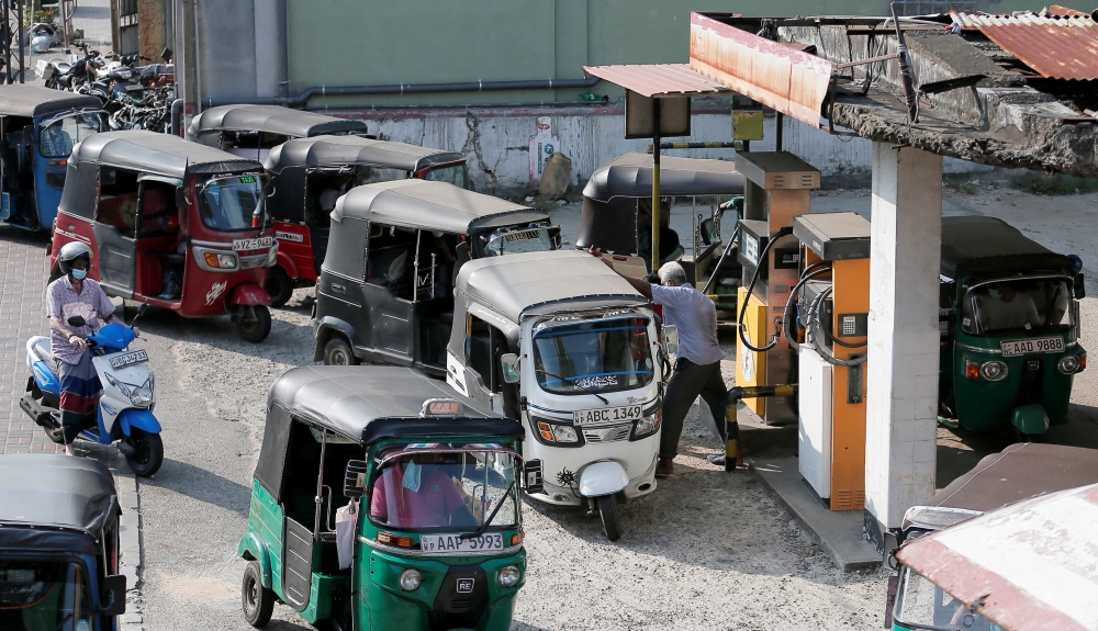 Three wheeler drivers wait in line to top up their tanks at a Ceylon Petroleum Corporation fuel station in Colomb