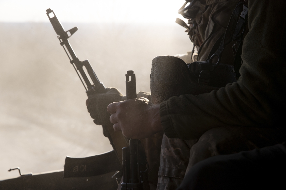 Ukrainian soldiers riding in the back of a truck at a front line position in Novozvanivka, Ukraine, Feb. 21, 2022.   (Tyler Hicks/The New York Times)