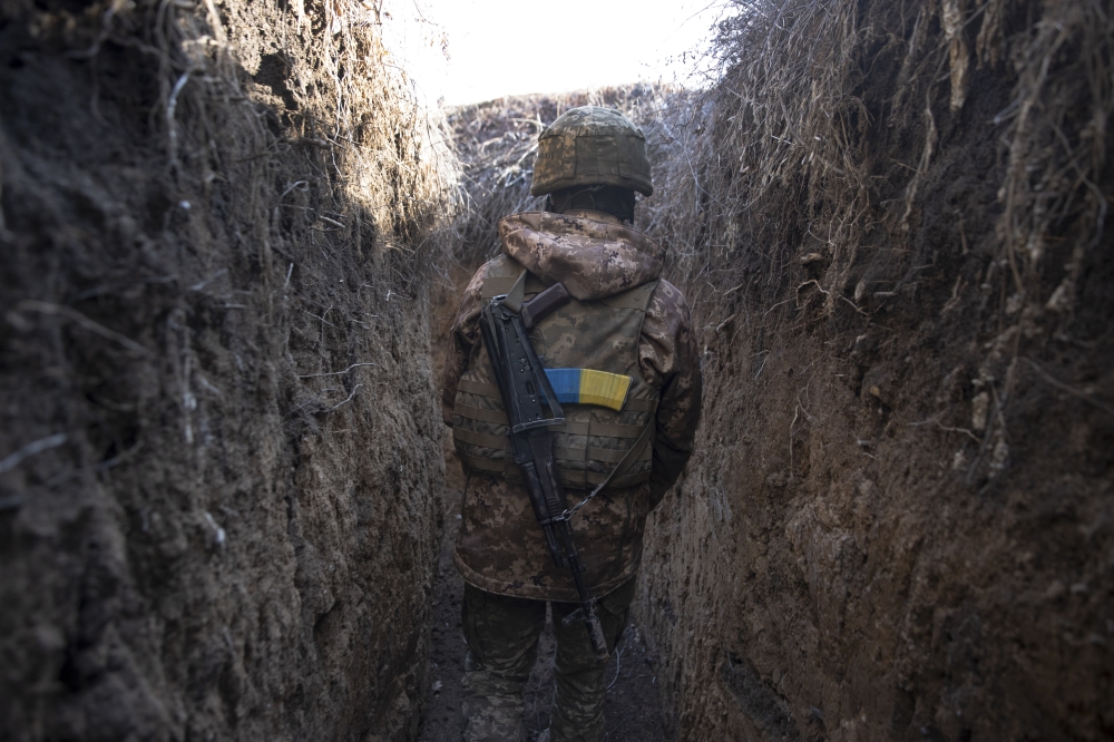 A Ukrainian soldier walks through a trench at a front line position, which has come under recent mortar attack, in Novozvanivka, Ukraine, Feb. 21, 2022. (Tyler Hicks/The New York Times)