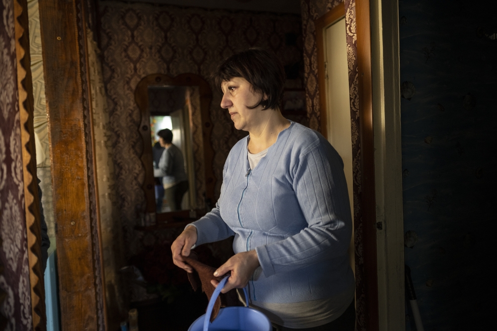 Ludmila Vyrizhok reacts to damage to her home hours after shelling in the village of Vrubivka, Ukraine, Feb. 21, 2022.  (Lynsey Addario/The New York Times)
