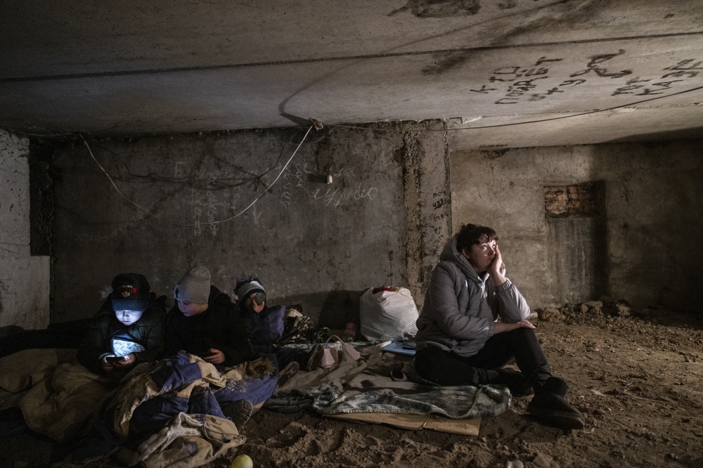 Kristina Makarenko, right, sits in a shelter after hearing separatists had returned to their artillery positions in the village of Vrubivka, Ukraine, Feb. 21, 2022. (Lynsey Addario/The New York Times)