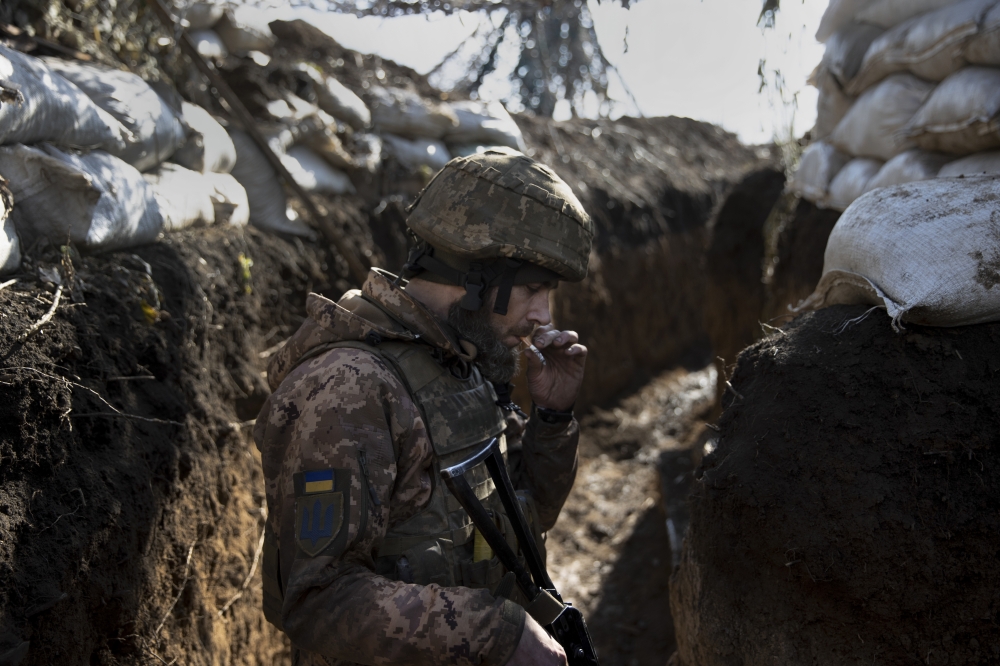 A Ukrainian soldier smokes in a trench at a front line position, which has come under recent mortar attack, in Novozvanivka, Ukraine, Feb. 21, 2022. (Tyler Hicks/The New York Times)